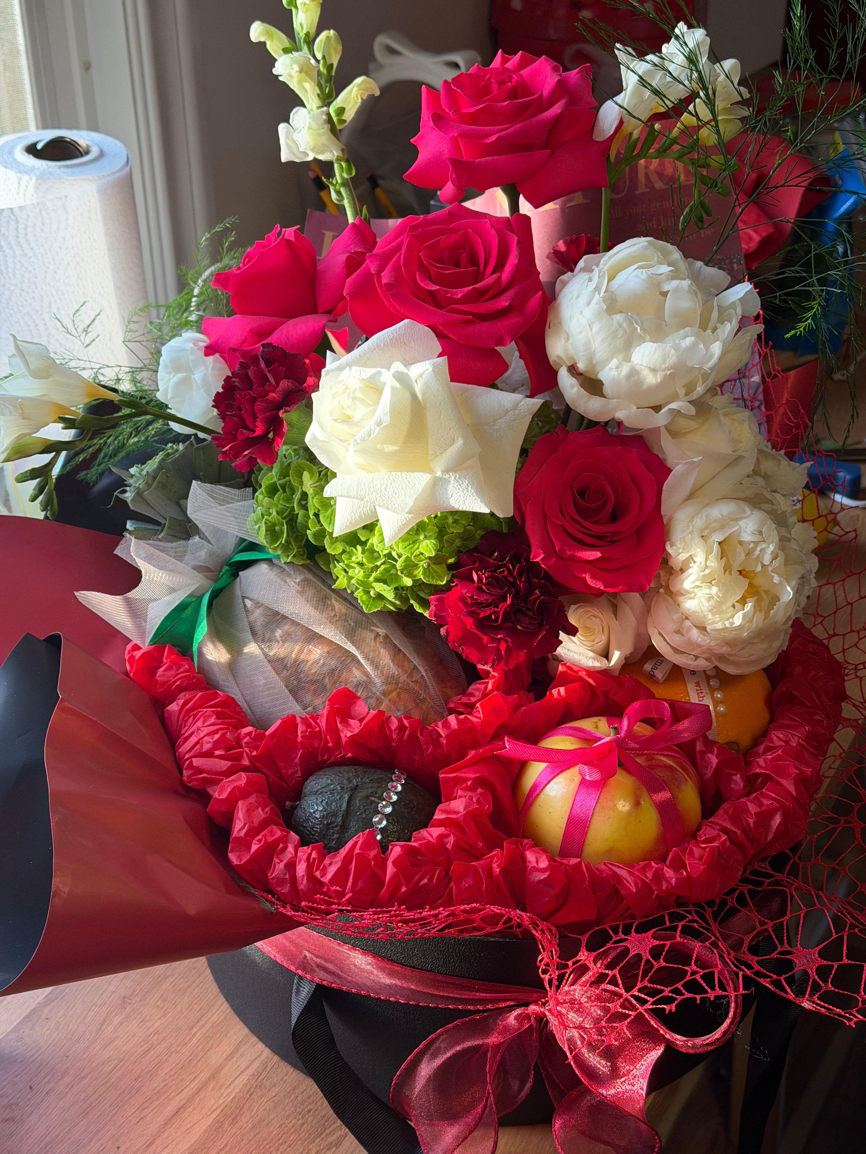 Bouquet of red and white flowers with decorative elements on a table.